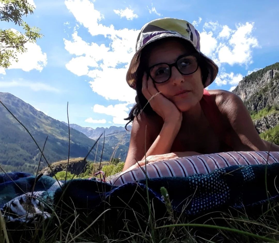 una donna seduta su una sedia all'esterno