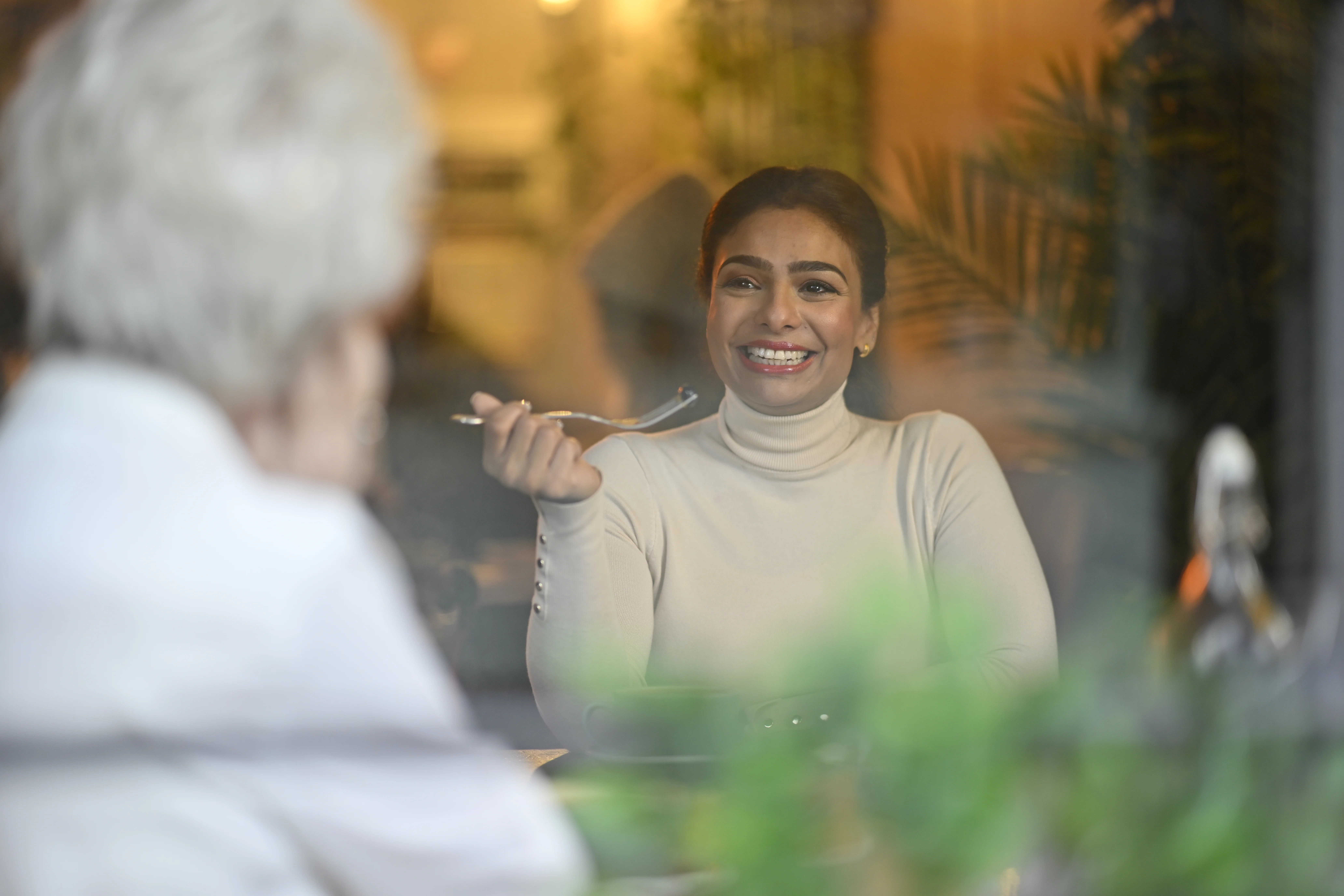 Une femme souriant en tenant une cuillère