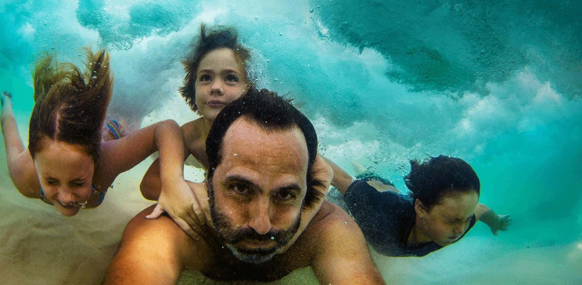 Man underwater diving with children