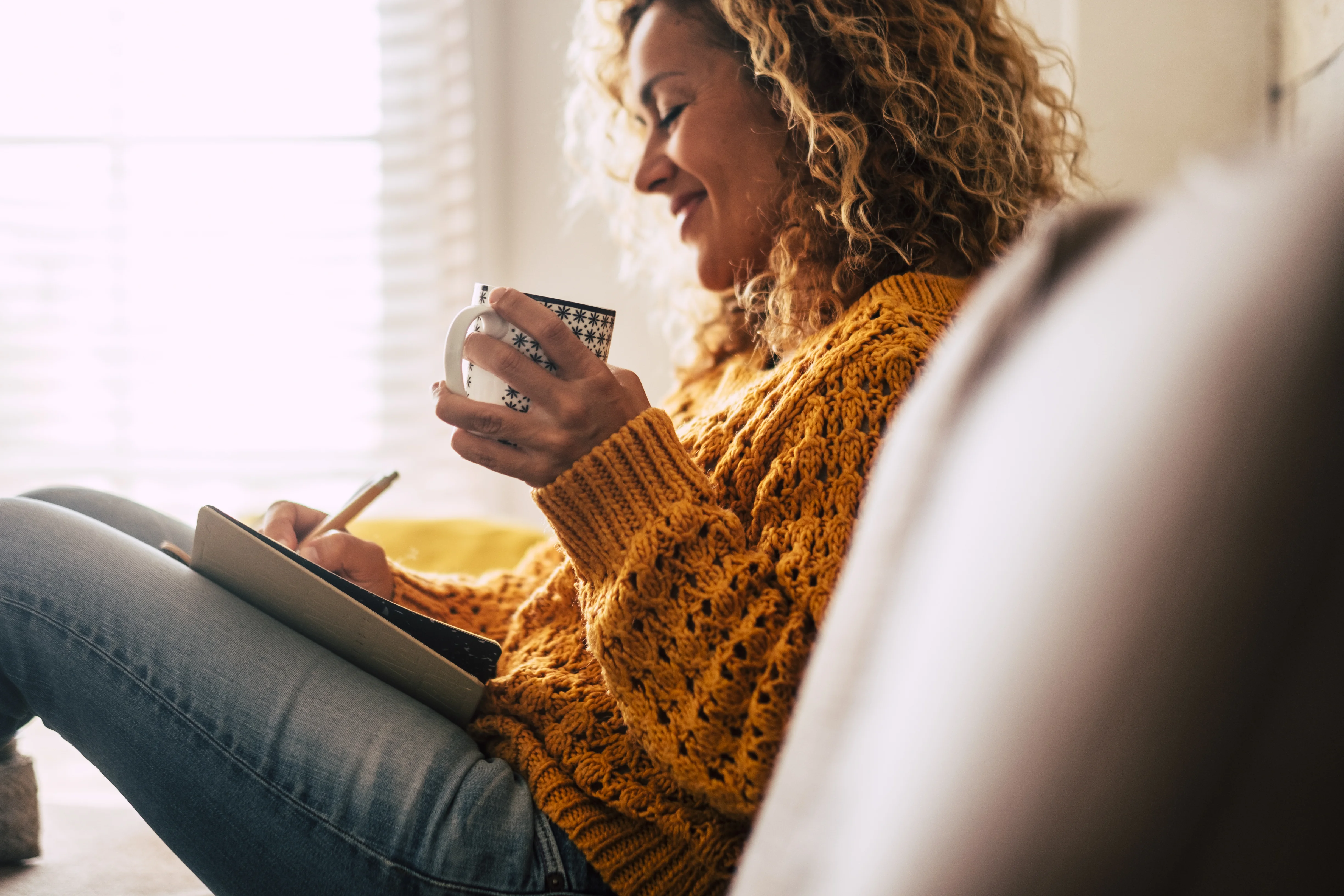 une femme assise sur un canapé et utilisant un téléphone
