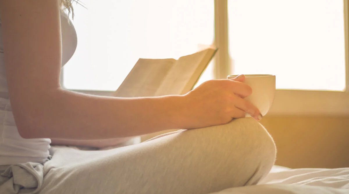 osoba držící šálek