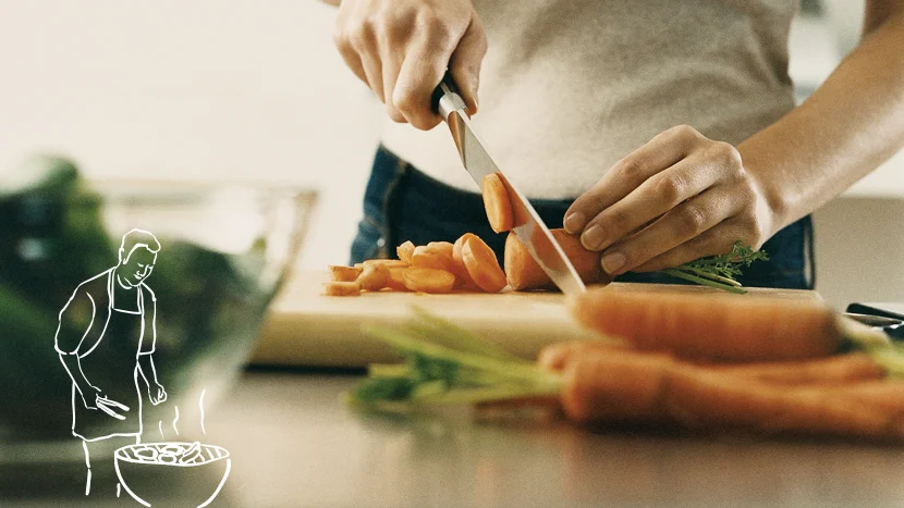 a close-up of a person chopping carrots